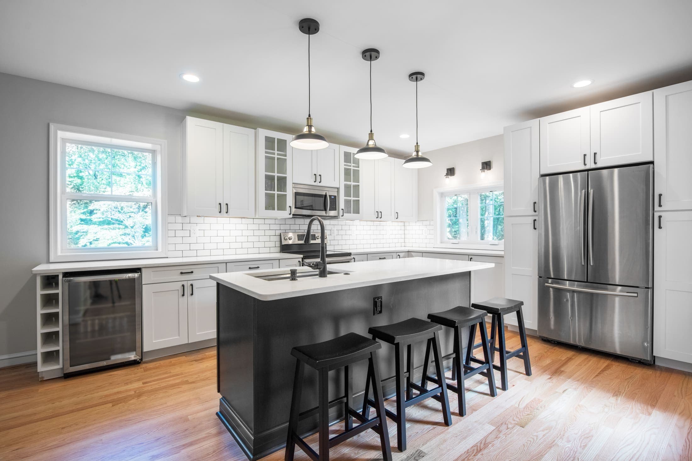 White shaker kitchen with a navy blue island and white quartz countertops